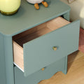 Teal bedside nightstand with open drawer revealing natural wood interior, brass knobs, lamp and plush toy on top — modern bedroom decor