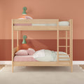 Light-wood bunk bed in kids' bedroom with coral two-tone wall, pink velvet bedding, green wall lamps and striped sheets