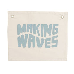 Decorative canvas wall hanging with the words "Making Waves" in blue letters.