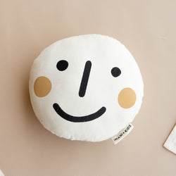 Smiley face cushion pillow for kids with beige background.