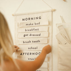 Child interacting with a daily routine chart for morning and afternoon tasks.