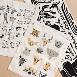 Illustrated alphabet print tea towels featuring various animal designs in black and white, perfect for kitchen decor and learning.