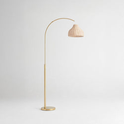 Elegant gold floor lamp with an arched design and a woven beige shade, perfect for modern interior lighting decor.
