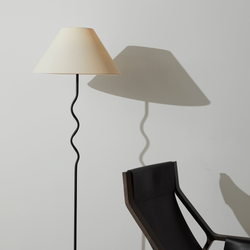 Modern floor lamp with cream shade beside a black minimalist chair against a neutral background.