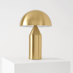 Golden modern table lamp with a dome-shaped shade on a white pedestal.