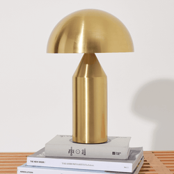 Elegant modern brass table lamp on stacked books for stylish home decor.