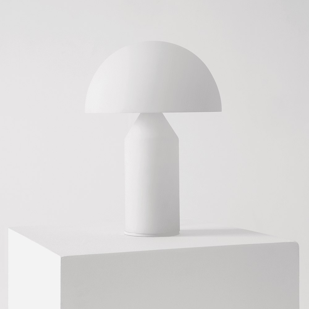 Minimalist white table lamp on a white pedestal, showcasing contemporary interior design.