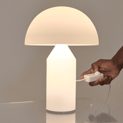 Contemporary table lamp with dome-shaped shade being switched on, interior lighting design.