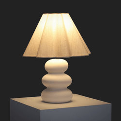 Contemporary table lamp with a beige fabric shade and a modern sculptural base.
