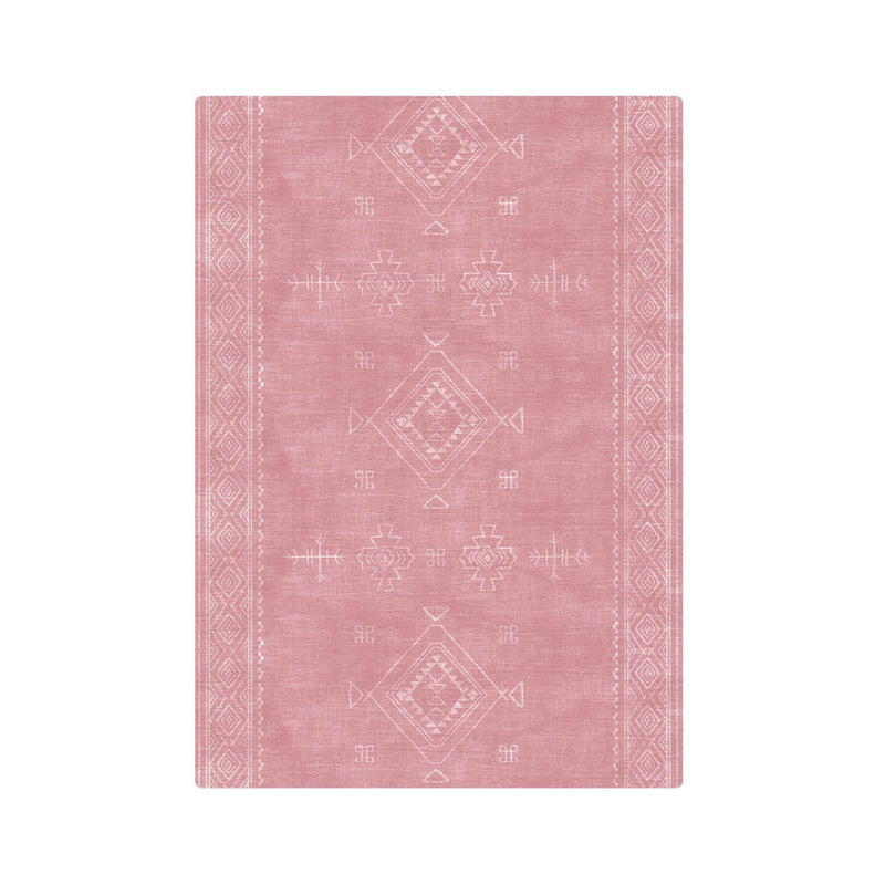 Pink bohemian area rug with tribal patterns and geometric designs on a white background.