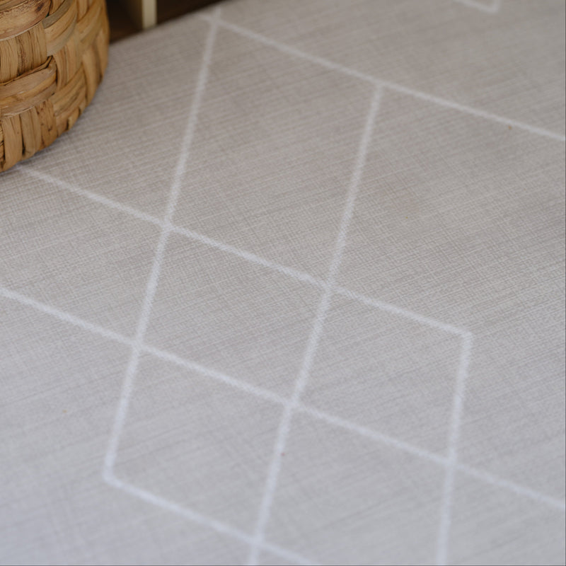 Woven basket on white geometric patterned background for stylish home decor.