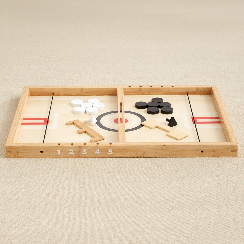Wooden tabletop curling game with black and white discs on a numbered board.