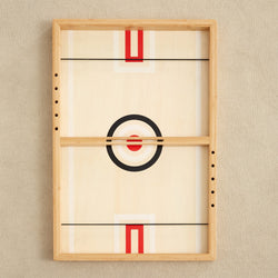 Wooden tabletop hockey game with target design on beige textured background.