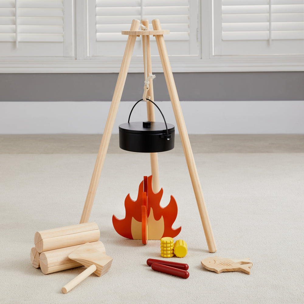 Toy wooden campfire set with logs, cooking pot, and food items for imaginative play.