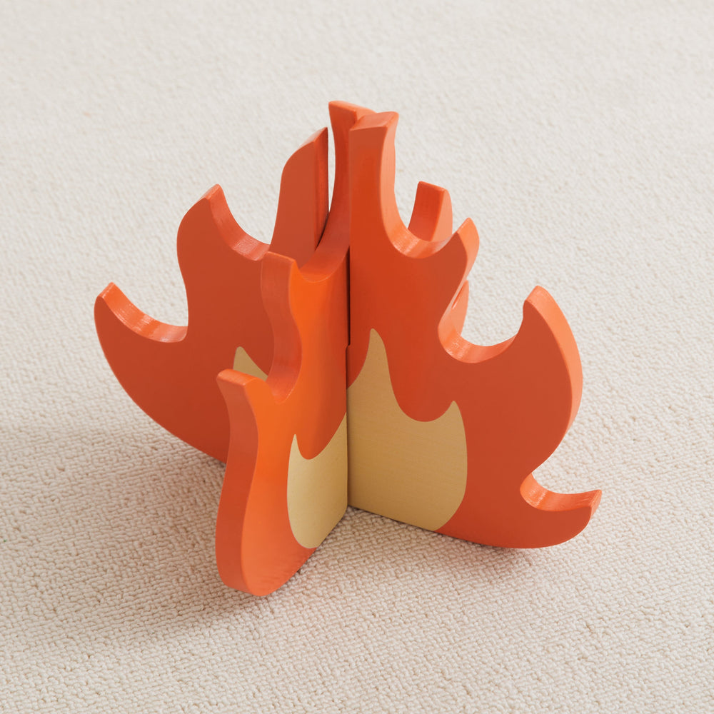 Wooden toy campfire on a beige carpet, educational and imaginative play accessory.