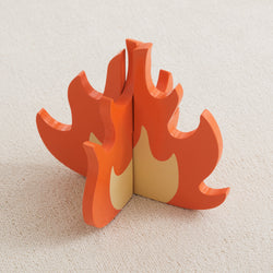 Wooden toy campfire on a beige carpet, educational and imaginative play accessory.