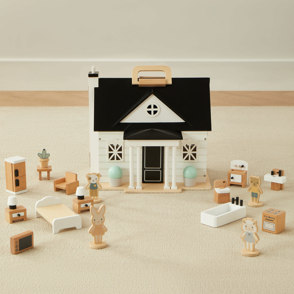 Toy dollhouse set with miniature wooden furniture and animal figures on beige carpet.