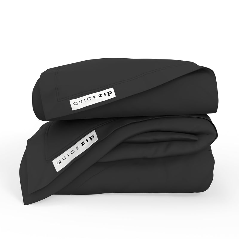 Folded black duvet covers with QuickZip labels, showcasing high-quality bedding for comfortable sleep.