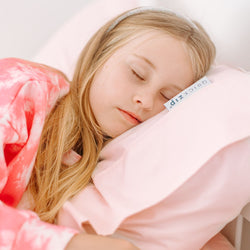 Sleeping child on soft pink pillow with matching pink tie-dye blanket — cozy kids bedding for restful bedtime and better sleep