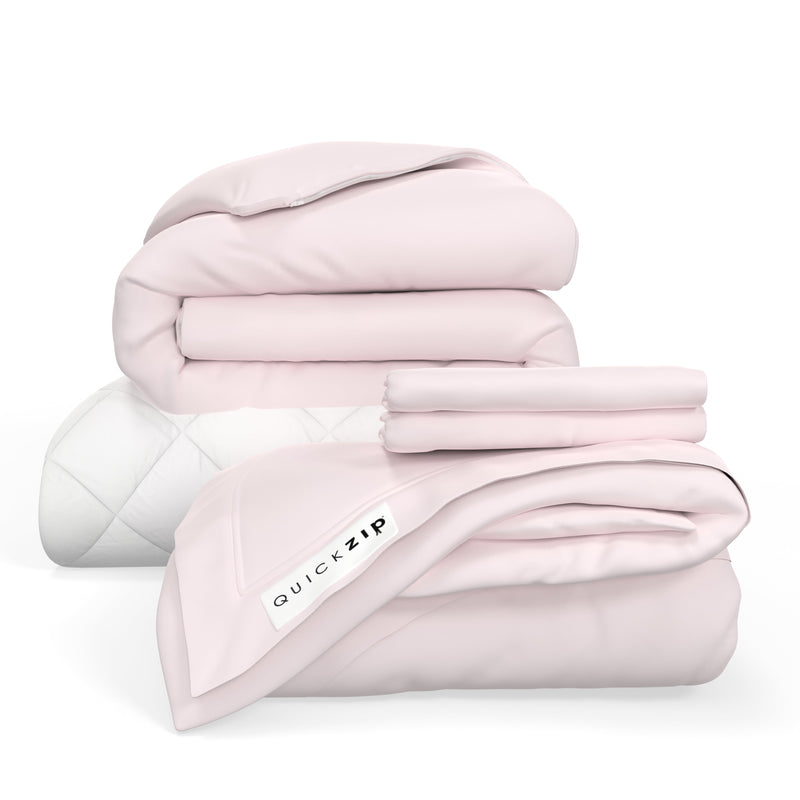 Folded pink bedding set with QuickZip label, including blankets and sheets.