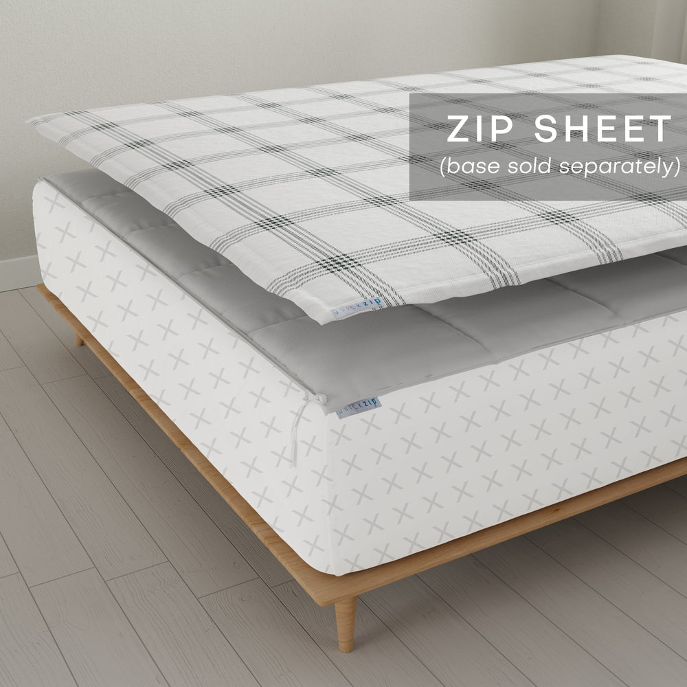 Modern zip sheet bedding on wooden bed frame, highlighting removable top layer for easy cleaning.