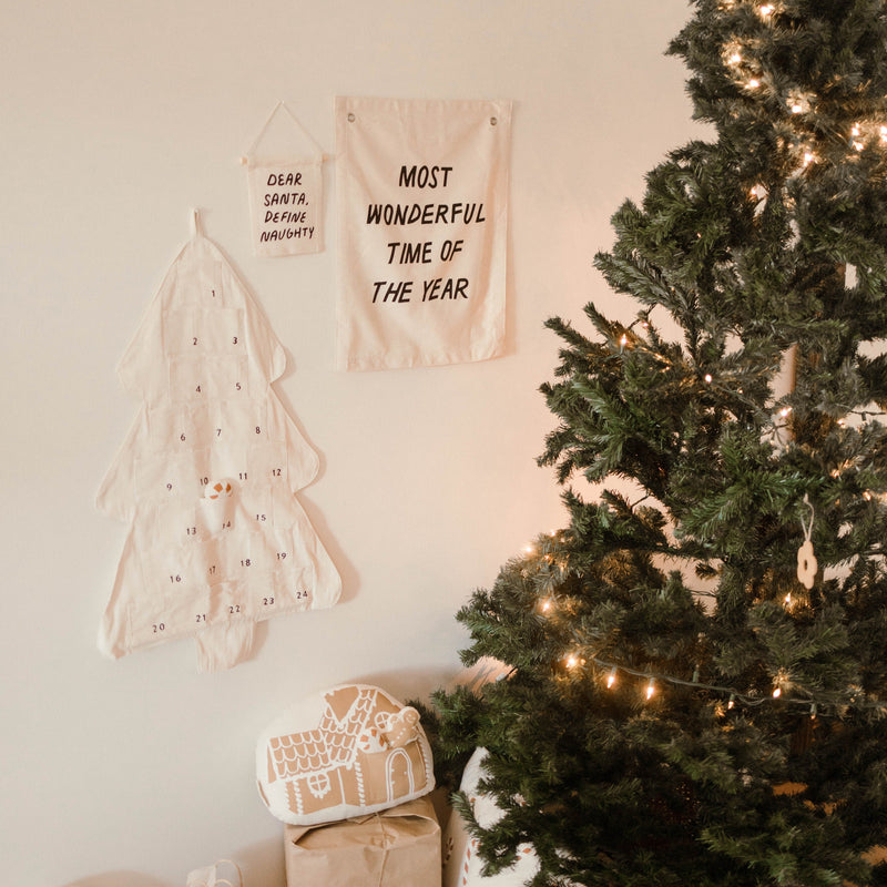 Cozy Christmas scene with decorated tree, festive wall banners, and wrapped gifts.