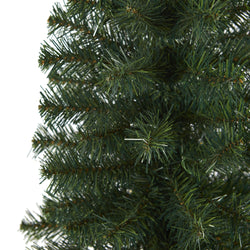 Close-up of realistic artificial Christmas tree branches with dense dark green PVC pine needles for holiday décor