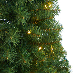 Close-up of artificial green Christmas tree branches with realistic pine needles and warm white LED string lights for holiday decor