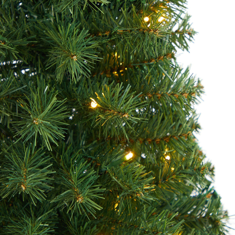 Close-up of artificial green Christmas tree branches with realistic pine needles and warm white LED string lights for holiday decor
