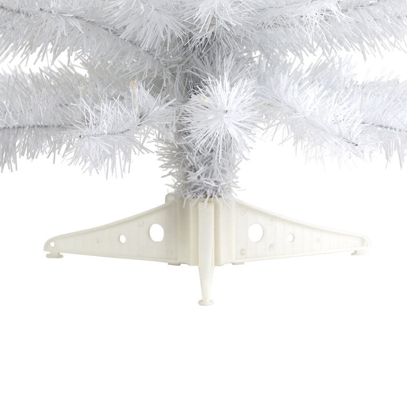 Close-up of white artificial Christmas tree branches and plastic tree stand on white background
