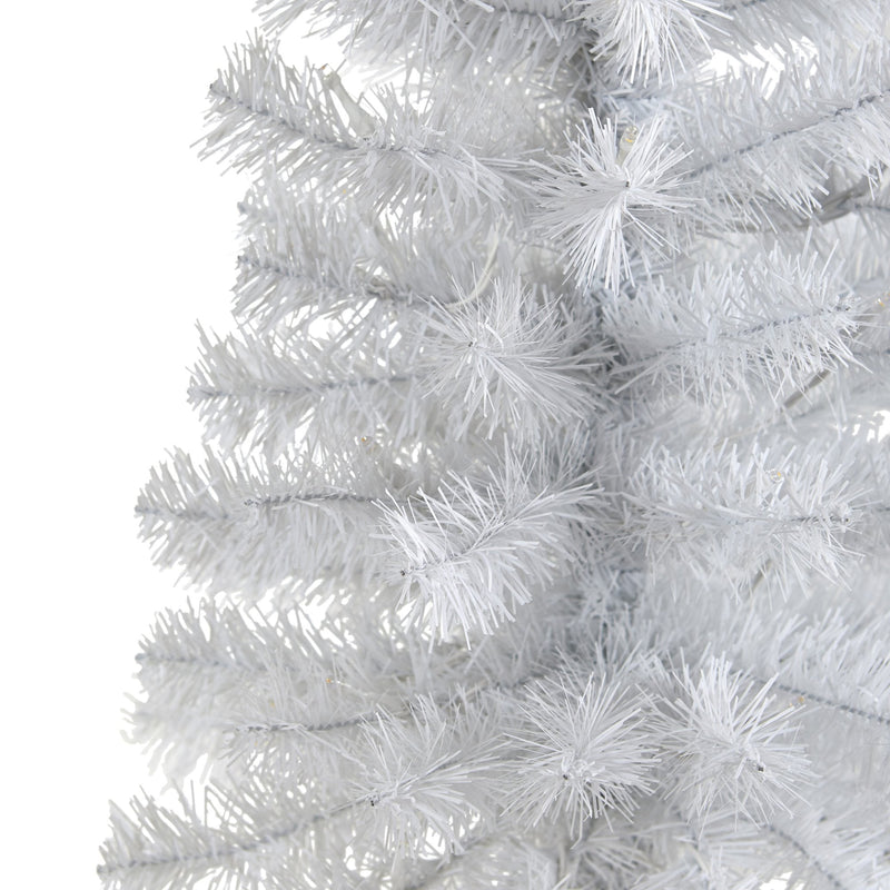 Close-up of white artificial Christmas tree branches with dense PVC needles, pre-lit LED lights and frosted snowy finish for holiday decor