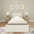 Children's bedroom with upholstered twin bed, wooden nightstands, blue lamps, green striped wallpaper, and rocket, moon, star framed art