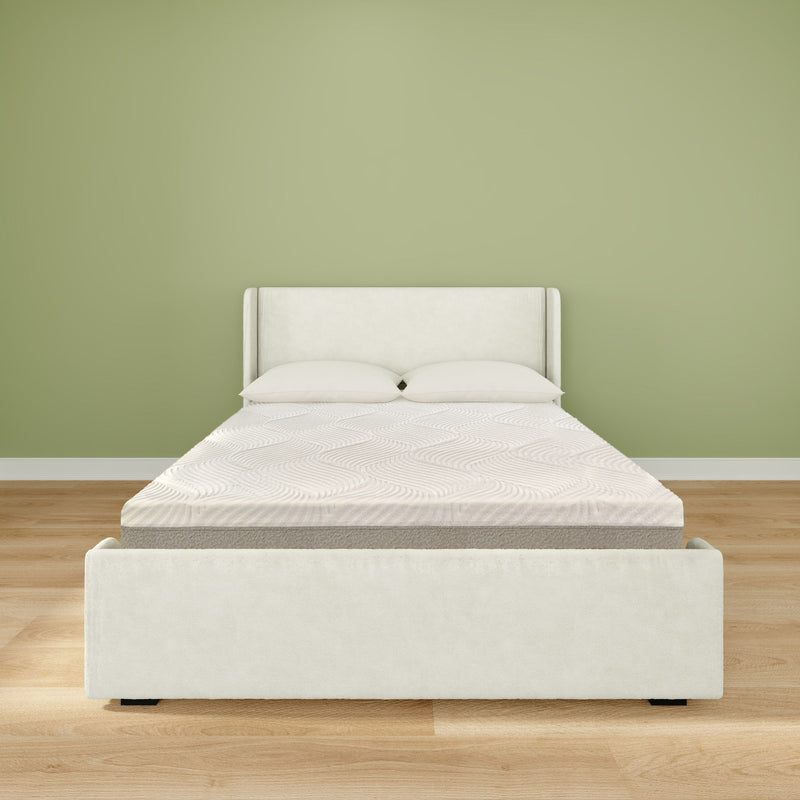 Minimalist modern bedroom interior with white upholstered bed frame, mattress and two pillows on light hardwood floor against a sage green accent wall