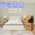 Cooling full-size mattress-in-a-box beside an upholstered bed in a pastel bedroom with nightstands and lamps, packaging reads "Better sleep begins here