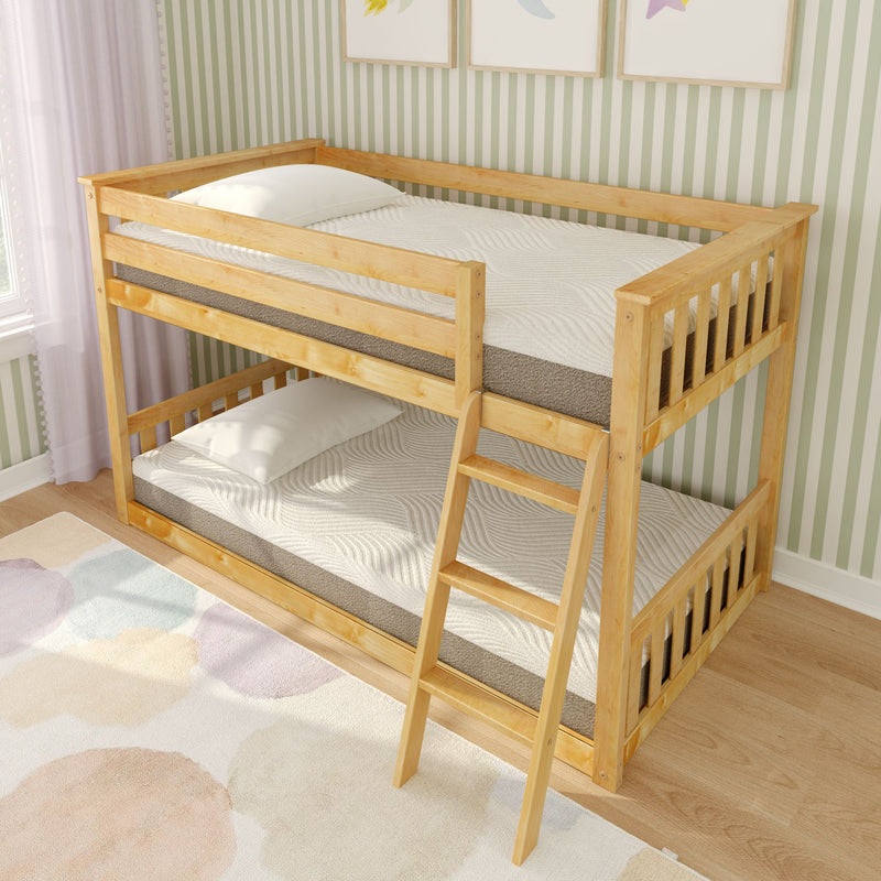 Pine wooden twin-over-twin bunk bed with ladder in children’s bedroom, white mattresses, pastel area rug and green striped wallpaper