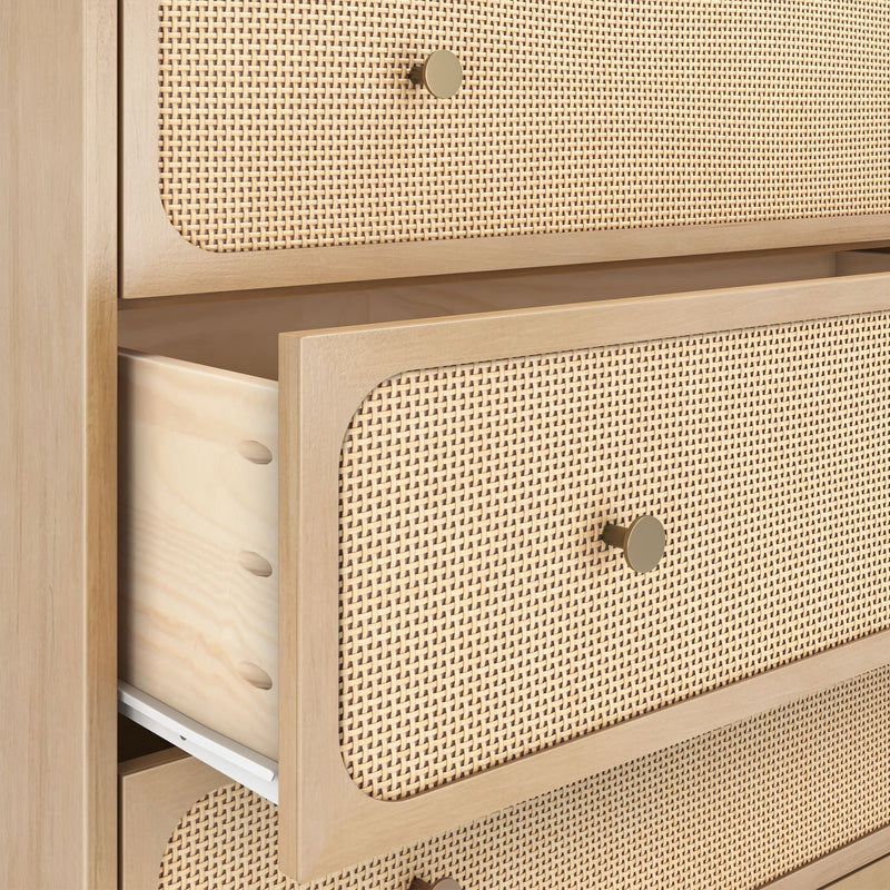 Light wood mid-century modern dresser with woven rattan (cane) drawer fronts, brass knobs and a partially open drawer showing dovetail joints.