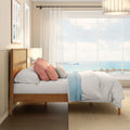 Coastal bedroom with wooden bed, white bedding, pastel pillows and large window overlooking ocean view