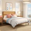 Coastal bedroom decor: light airy beach house bedroom with rattan headboard, coral and turquoise pillows, white bedding, surfboard wall art and ocean view