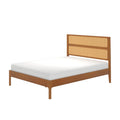 Mid-century modern wooden platform bed frame with woven rattan cane headboard and white mattress in warm wood finish