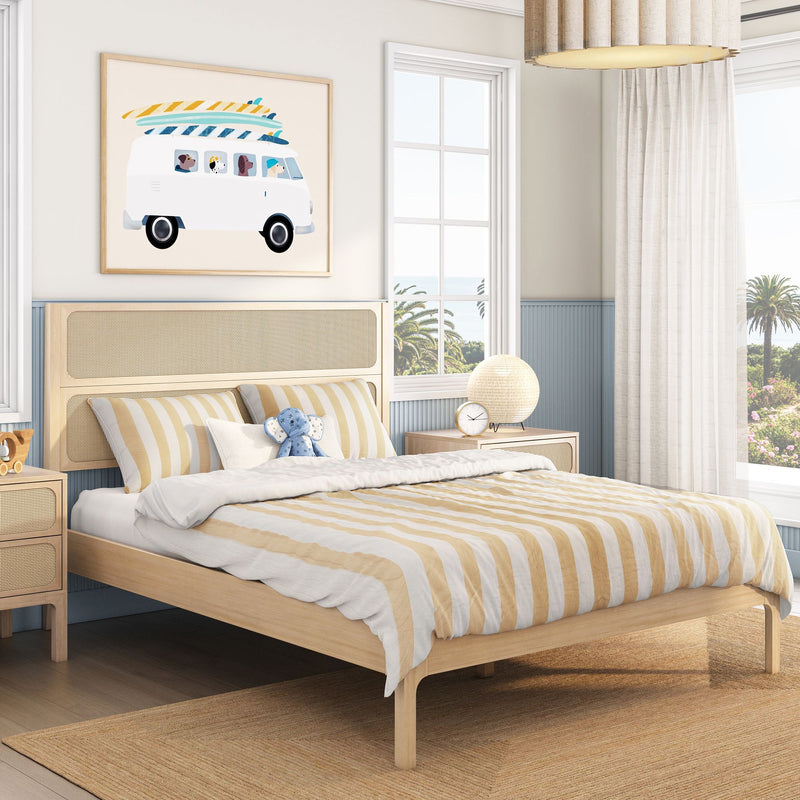 Coastal kids bedroom with light wood bed, rattan headboard, yellow striped bedding, surf-van wall art and palm-tree window view
