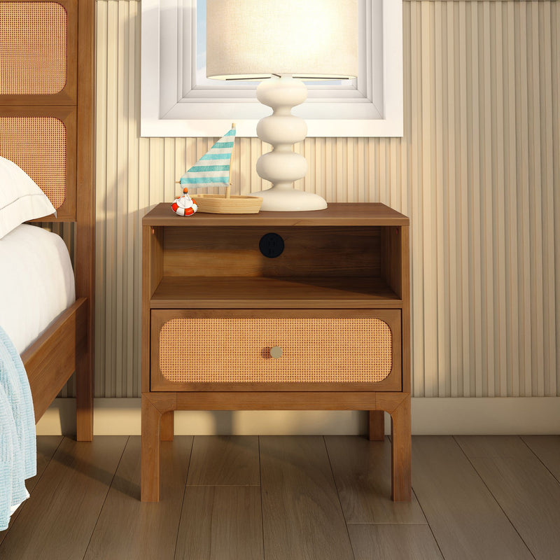 Wooden nightstand with woven rattan drawer, white ceramic table lamp and small sailboat decor in modern coastal bedroom