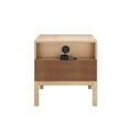 Modern light wood bedside table with single drawer, open shelf and built‑in cable grommet holding coiled black power cord