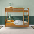 Modern wooden bunk bed in children's room with green two-tone walls, mustard velvet pillows, striped sheets, ladder and mint wall lamps