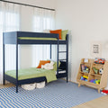 Bright modern kids' bedroom featuring a navy bunk bed with ladder, green bedding and orange pillows, blue-striped rug and wooden toy organizer with children's toys and storage