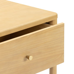 Close-up of modern light-wood nightstand with partially open drawer and brass knob, Scandinavian natural finish