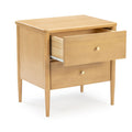 Mid-century modern light wood two-drawer nightstand with tapered legs and brass knobs, open top drawer, minimalist bedside table