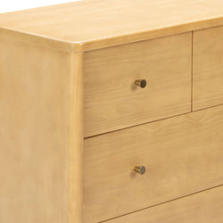 Close-up of light maple wood three-drawer dresser with rounded edges and brass knob pulls, modern minimalist bedroom furniture