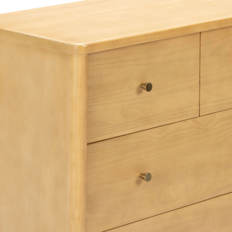 Close-up of light maple wood three-drawer dresser with rounded edges and brass knob pulls, modern minimalist bedroom furniture