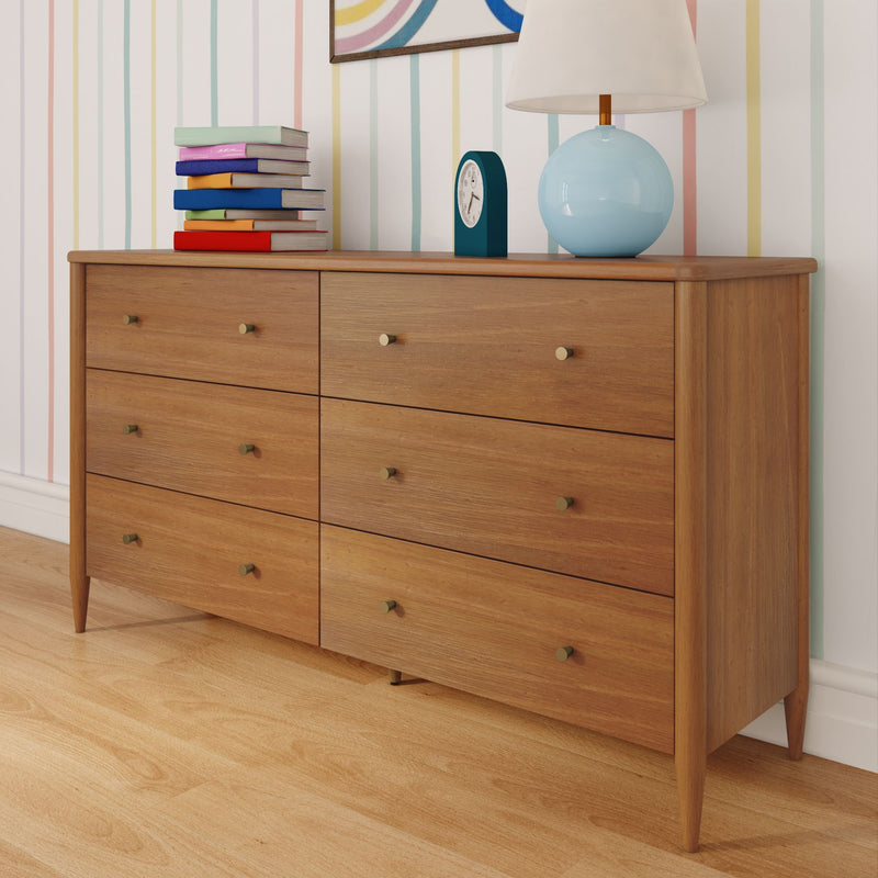 Mid-century modern six-drawer wooden dresser on hardwood floor with blue globe table lamp, teal alarm clock, colorful stacked books and pastel striped wallpaper