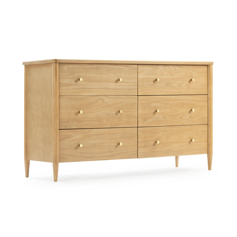Mid-century modern six-drawer dresser in light wood finish with round brass knobs and tapered legs on white background